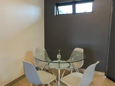 a glass table and chairs in a room at The Eyrie in Nelspruit