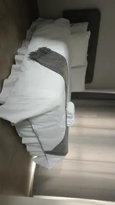 a bed with white sheets and pillows in a room at The Eyrie in Nelspruit