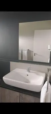 a bathroom with a white sink and a mirror at The Eyrie in Nelspruit