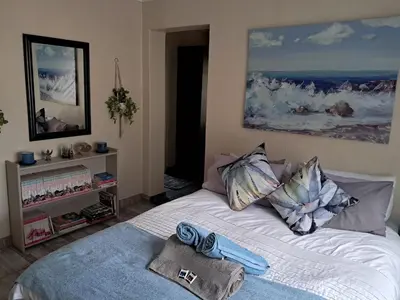a bedroom with a bed with towels on it at Sunflower Stables Cottage in the Garden in Midrand