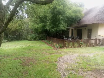 a house with a yard with a fence and a tree at Sunflower Stables Cottage in the Garden in Midrand