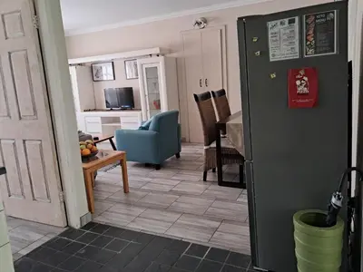 a kitchen and living room with a black refrigerator at Sunflower Stables Cottage in the Garden in Midrand