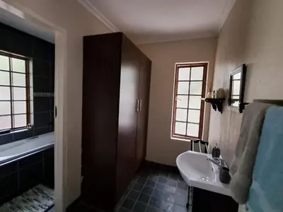 a bathroom with a sink and a toilet and a tub at Sunflower Stables Cottage in the Garden in Midrand