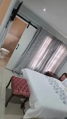 a bedroom with a bed and a window at Ntale Guest House in Benoni