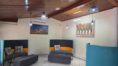 a waiting room with two chairs and a painting on the wall at Ntale Guest House in Benoni
