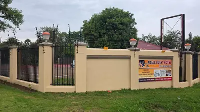 a fence with a gate with a sign on it at Ntale Guest House in Benoni