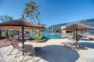 a group of chairs and umbrellas next to a pool at East Luxe BNB 2bed 2bath in Pretoria