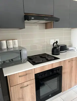 a kitchen with a stove and a microwave at East Luxe BNB 2bed 2bath in Pretoria