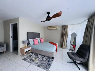 a bedroom with a bed and a person flying in the air at Olives by Agnes 31 in Hartbeespoort