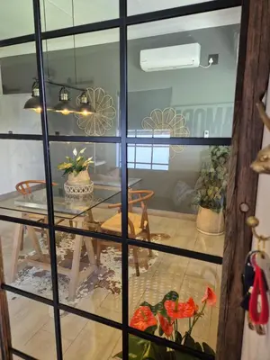a dining room with a table and a glass window at Hibiscus at Bougainvillea House in Pretoria