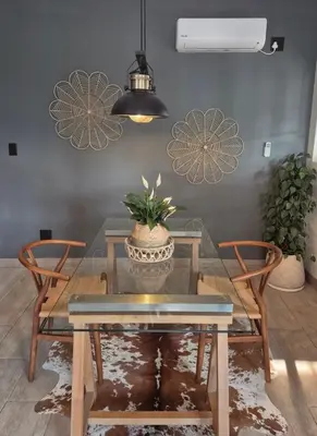 a dining room with a glass table and two chairs at Hibiscus at Bougainvillea House in Pretoria