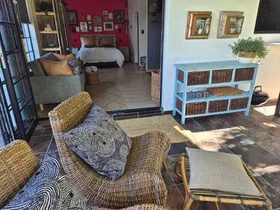 a living room with two chairs and a couch at Hibiscus at Bougainvillea House in Pretoria
