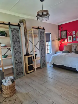 a bedroom with red walls and a bed with open doors at Hibiscus at Bougainvillea House in Pretoria