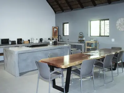 a large kitchen with a wooden table and chairs at Nzenga Lodge in Hoedspruit