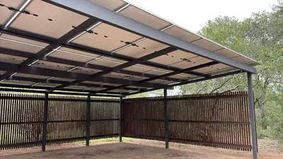 a large metal pavilion with a wooden fence at Nzenga Lodge in Hoedspruit