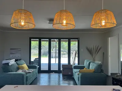 a living room with two blue couches and lights at One Eight Seven on Moepel in Malelane