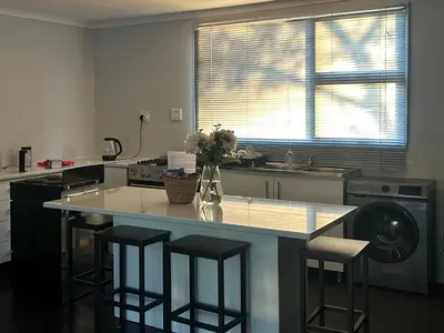 a kitchen with a large island with bar stools at One Eight Seven on Moepel in Malelane