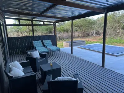 a deck with couches and chairs and a table at One Eight Seven on Moepel in Malelane