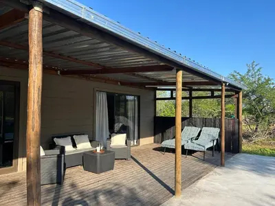a pergola on a patio with chairs and a couch at One Eight Seven on Moepel in Malelane