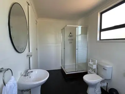 a bathroom with a sink and a toilet and a mirror at One Eight Seven on Moepel in Malelane