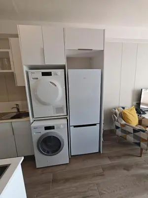 a kitchen with a washing machine and a refrigerator at Cosy Regency menylin apartment in Pretoria