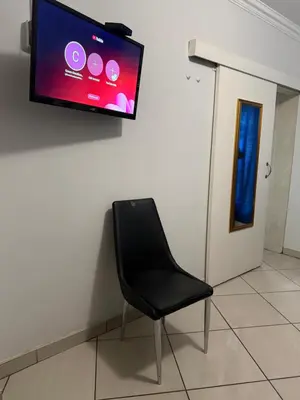 a black chair sitting in a room with a flat screen tv at Crown Guesthouse Meyerspark in Pretoria