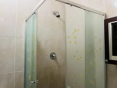 a shower with a glass door in a bathroom at Crown Guesthouse Meyerspark in Pretoria