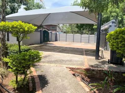a large white umbrella sitting in a yard at Crown Guesthouse Meyerspark in Pretoria