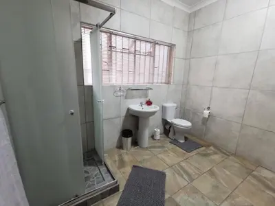 a bathroom with a toilet and a shower and a sink at 34th on Pierneef in Pretoria