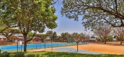 a tennis court in a park with trees at Mooikloof Ridge Hide Out in Pretoria