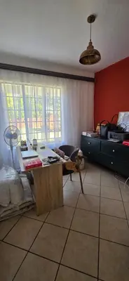 a living room with a table and a bed at Mooikloof Ridge Hide Out in Pretoria
