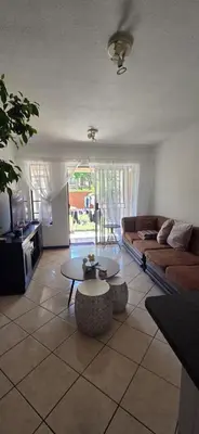 a living room with a couch and a table at Mooikloof Ridge Hide Out in Pretoria