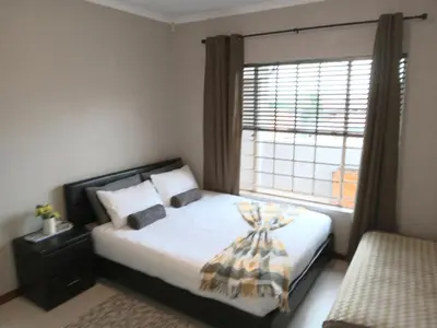 a bedroom with a bed with a large window at Nested at L&MX in Centurion