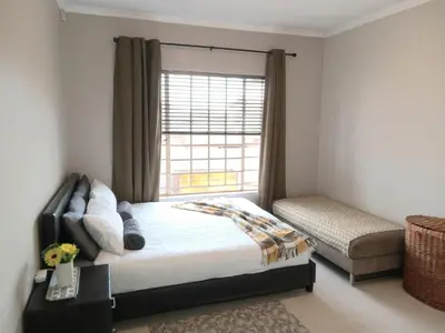 a bedroom with a bed and a window at Nested at L&MX in Centurion