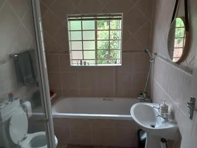 a bathroom with a bath tub and a sink at Nested at L&MX in Centurion