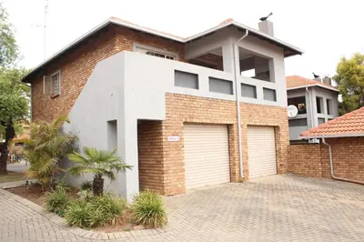 a brick house with two garage doors on a driveway at Nested at L&MX in Centurion