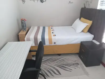 a small bedroom with a bed and a desk at Nested at L&MX in Centurion