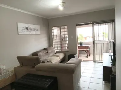a living room with a couch and chairs and a table at Nested at L&MX in Centurion
