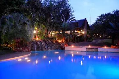 a large swimming pool at night with a house in the background at Pestana Kruger Lodge in Malelane