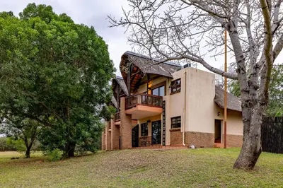 an exterior view of a house with trees at Pestana Kruger Lodge in Malelane