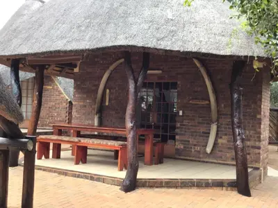 a small hut with a bench and a roof at Big Tuskers Bush Camp in Marloth Park