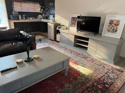 a living room with a couch and a tv at 1170 on Kuskoraal - Apartment, Pretoria in Pretoria