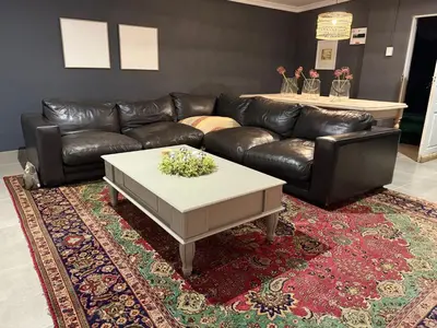 a living room with a leather couch and a coffee table at 1170 on Kuskoraal - Apartment, Pretoria in Pretoria