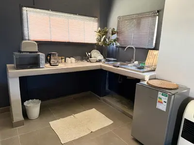 a kitchen with a counter with a microwave and a refrigerator at 1170 on Kuskoraal - Apartment, Pretoria in Pretoria