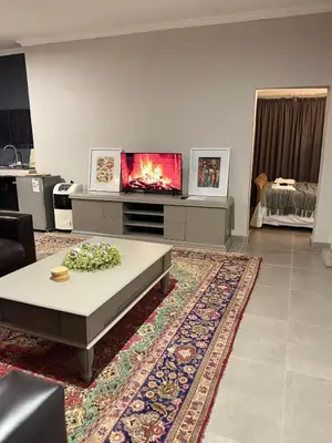 a living room with a tv and a coffee table at 1170 on Kuskoraal - Apartment, Pretoria in Pretoria