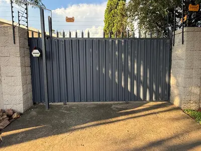 a gate to a driveway with a fence at 1170 on Kuskoraal - Apartment, Pretoria in Pretoria