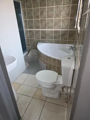 a bathroom with a toilet and a tub and a sink at The Good Samaritan 2 in Witbank