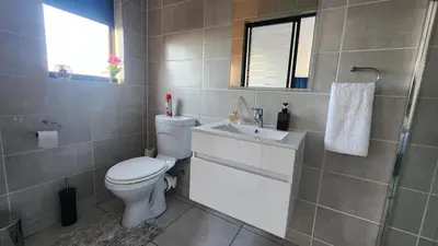 a bathroom with a toilet and a sink at White House At The Blyde Crystal Lagoon in Pretoria