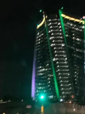 a tall building with green lights on it at night at Ellipse Lux Hotel - Apartment in Midrand