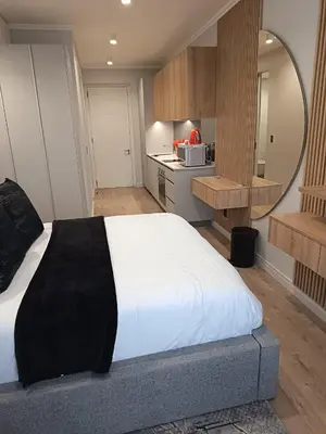 a bedroom with a large bed and a kitchen at Ellipse Lux Hotel - Apartment in Midrand